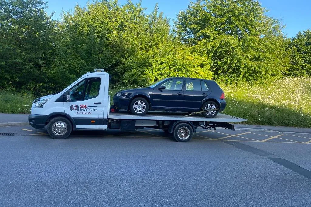 A black Volkswagen Golf on the SSC Motors truck
